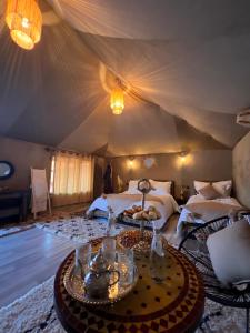 a bedroom with two beds in a tent at Aladdin Merzouga Camp in Merzouga