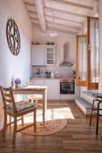 eine Küche mit weißen Schränken sowie einem Tisch und Stühlen in der Unterkunft Casa Cantagalli in Tavarnuzze
