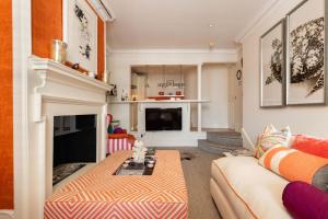 sala de estar con sofá y chimenea en A Royal Residence – Stylish 2 Bedroom in Kensington en Londres