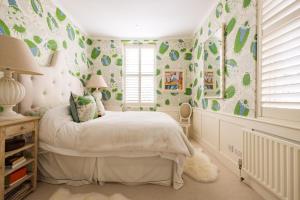 - une chambre avec un lit orné de papier peint vert et blanc dans l'établissement A Royal Residence – Stylish 2 Bedroom in Kensington, à Londres