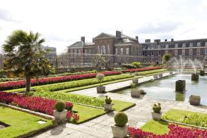 ein Gebäude mit einem Garten mit Blumen und einem Teich in der Unterkunft A Royal Residence – Stylish 2 Bedroom in Kensington in London
