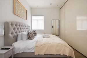 1 dormitorio con 1 cama grande y cabecero grande en Luxury and Cool 2 bedroom in Notting Hill en Londres