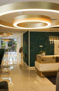 a lobby with a green accent wall and a circular ceiling at M-Pire Hotel Berlin in Berlin