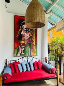 a red couch with red pillows and a painting at Moi Galle Fort by DBI in Galle