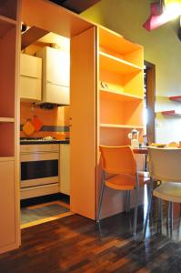 eine Küche mit orangefarbenen Schränken sowie einem Tisch und Stühlen in der Unterkunft La Domus Picta in Verona