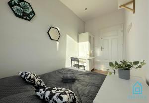 a bedroom with a bed with a pillow and a desk at Lambert Room in Gdańsk