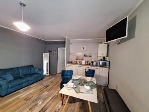- un salon avec une table et un canapé bleu dans l'établissement Magic Apartments Hunedoara, à Hunedoara