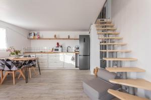 uma cozinha e sala de jantar com uma escada em espiral em Joli Mazet indépendant em La Motte
