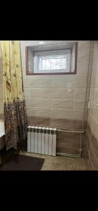baño con ventana y cortina de ducha en Квартира, en Shymkent