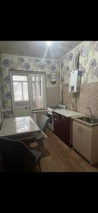 a kitchen with a sink and a table and a sink at Квартира in Shymkent