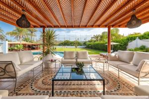 a patio with white couches and a glass table at Exclusive Home Maspalomas in San Bartolomé