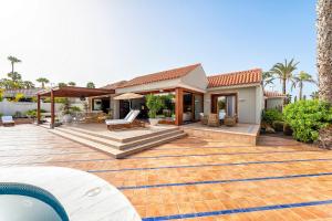 a house with a patio and a swimming pool at Exclusive Home Maspalomas in San Bartolomé
