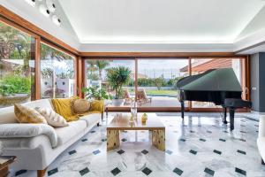 a living room with a white couch and a piano at Exclusive Home Maspalomas in San Bartolomé