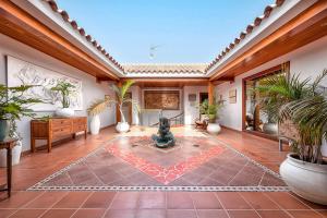 a courtyard with a fountain in the middle of a room with plants at Exclusive Home Maspalomas in San Bartolomé