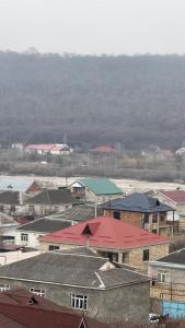 a group of buildings with red roofs in a town at Riverside villa in Qusar