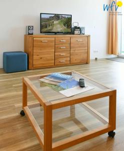 une table basse dans un salon avec une télévision dans l'établissement Haus am alten Leuchtturm Ferienwohnung 8, à Wangerooge