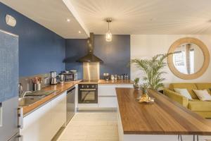 kuchnia z niebieskimi ścianami i drewnianym stołem w obiekcie * PERLE B'LEU * Hypercentre * Lagon * Plage * w mieście Saint-Leu