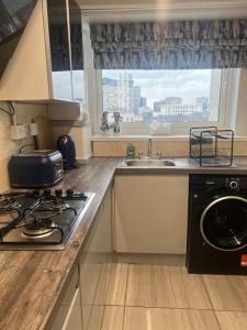 uma cozinha com um fogão, um lavatório e uma janela em Birminghams Finest em Birmingham