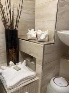 Baño con estante con toallas y lavamanos en Birminghams Finest en Birmingham