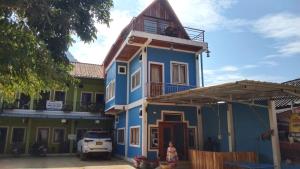 a blue and green house with a car parked in front at Amphai Guest house in Nongkhiaw