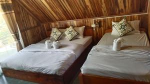 two beds with stuffed animals on them in a room at Amphai Guest house in Nongkhiaw +5 photos