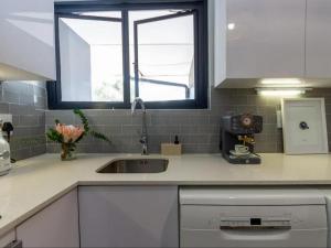a kitchen counter with a sink and a window at Parioli Court in Cape Town