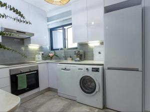 a kitchen with a washing machine and a refrigerator at Parioli Court in Cape Town