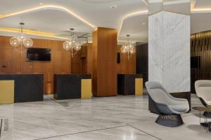 a lobby with chairs and a television and chandeliers at Le Meridien Batumi in Batumi