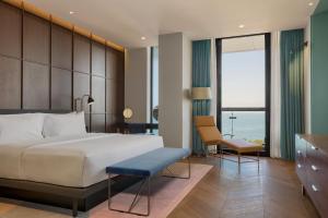 a bedroom with a large bed and a desk and chair at Le Meridien Batumi in Batumi