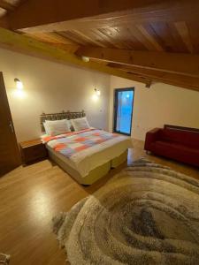 een slaapkamer met een bed en een tapijt bij Gökler Çiftliğinde Çatı Katı in Foca