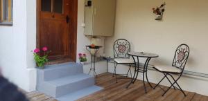 - une terrasse couverte avec une table, des chaises et une porte dans l'établissement Hobbit House - Frodo, à Därligen