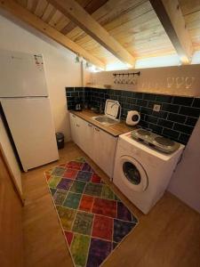een keuken met een wasmachine bij Gökler Çiftliğinde Çatı Katı in Foca