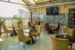 een restaurant met tafels en stoelen op een balkon bij Limpopo Suites in Nairobi