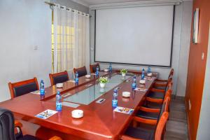 een conferentieruimte met een grote houten tafel en stoelen bij Limpopo Suites in Nairobi