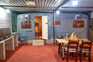 a dining room with a table and a train car at Lemon Garden Camper in Chania Town