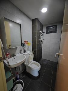 La salle de bains est pourvue de toilettes blanches et d'un lavabo. dans l'établissement Modern Comfy Suite Room-9Pax, à Perai
