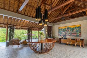 a living room with a table and a desk at The Sterling Villas in Uluwatu