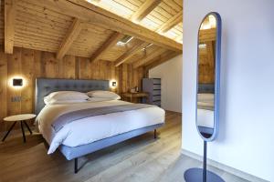a bedroom with a bed and a mirror at Locanda Boton D'Oro in Auronzo di Cadore