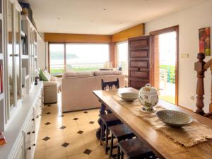 een eetkamer met een tafel en een bank bij Casa Rompeolas - Monabri in Suances