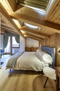 ein Schlafzimmer mit einem großen Bett und Holzdecken in der Unterkunft Locanda Boton D'Oro in Auronzo di Cadore