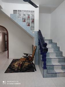 a staircase in a building with a bench and a chair at R&R HOMESTAY TAMAN HARMONI in Simpang Renggam