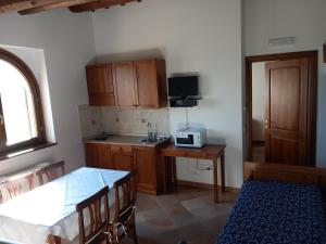 a kitchen with wooden cabinets and a sink and a table at Antico Borgo Carceri & Wellness in Bevagna