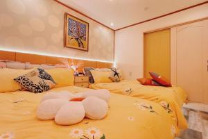 um quarto com duas camas com flores em 锦·【銀太閤】名古屋駅から徒歩圏内、貸切一戸建て em Nagoia