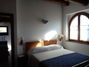 Schlafzimmer mit einem Bett und einem Fenster in der Unterkunft Antico Borgo Carceri & Wellness in Bevagna