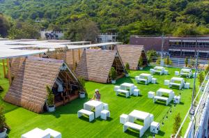 Tawaen Caza Sky Camping في كو لان: إطلالة علوية على مبنى به عشب أخضر وكراسي بيضاء