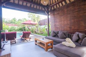 a living room with a couch and a table at The Awan Villas - CHSE Certified in Seminyak