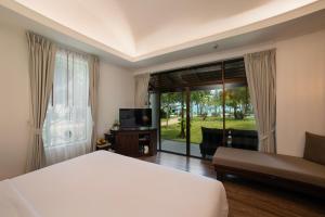 a hotel room with a bed and a large window at Celes Samui in Bophut 