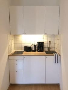 a kitchen with white cabinets and a sink at Fancy It-District Dresden Neustadt / Louisenstraße in Dresden