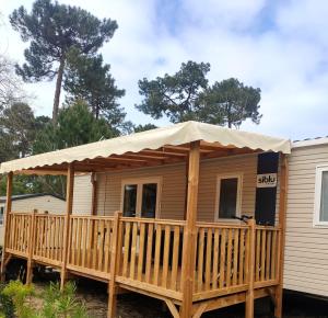 uma casa com um alpendre com um toldo em A la brise du Ferret em Lège-Cap-Ferret