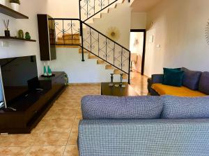 a living room with a couch and a staircase at Athena Two-bedroom Townhouse in Paphos City